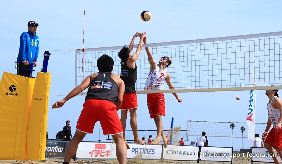 Photograph of beach volleyball players.