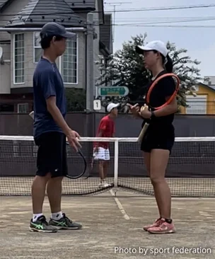 Photograph of Doubles players communicating with hand signs.